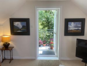 an open door to a patio with potted plants at Perfect for two close to Kenmare in Kenmare