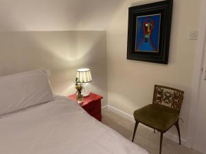 a bedroom with a bed and a chair and a lamp at Perfect for two close to Kenmare in Kenmare