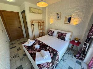 a bedroom with a bed with towels on it at Afet inn in Çeşme