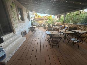 a patio with tables and chairs on a wooden deck at Afet inn in Çeşme