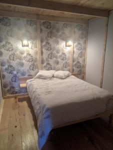 a bed with two pillows on it in a bedroom at Le relais de la mine in Champagnac