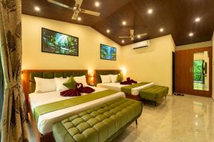 a hotel room with two beds and a couch at kumba stay in Kumbakonam
