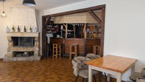 a living room with a table and a fireplace at L'auberge des Érables in La Pesse
