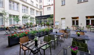 an outdoor patio with tables and chairs and flowers at Hotel Garden Court in Prague