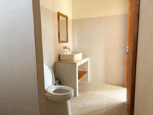 a bathroom with a toilet and a sink at Kayana Amed in Amed