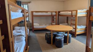 a room with a table and four bunk beds at L'auberge des Érables in La Pesse +11 photos