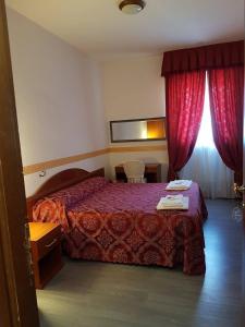 Habitación de hotel con cama y cortinas rojas en Villa Altieri, en Albano Laziale