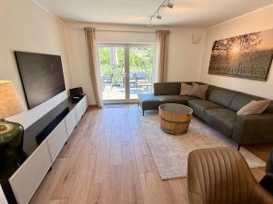 a living room with a couch and a tv at Gimmeldinger Haus in Neustadt an der Weinstraße