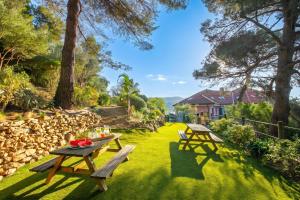 two picnic tables on the grass in a yard at Seaview Pool Retreat - Il Poggio in Marina di Andora