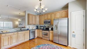 a kitchen with wooden cabinets and a stainless steel refrigerator at Rehoboth Crossing --- 19913 Ames Drive #106 in Rehoboth Beach