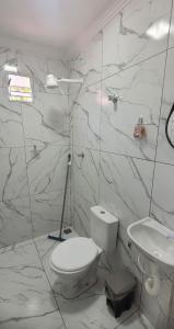 a white bathroom with a toilet and a sink at Loft urbano in Martins