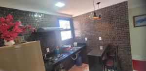 a kitchen with black brick walls and a sink at Loft urbano in Martins