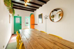 a dining room with a wooden table and yellow chairs at Balili Surf House in Baleal
