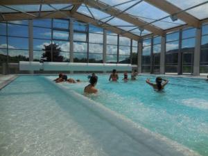 a group of people swimming in a swimming pool at Les grands chalets in Chaillol