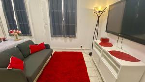 a living room with a couch and a flat screen tv at Gite Escale en Ville in Louviers +3 photos