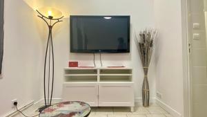 a living room with a tv on a wall at Gite Escale en Ville in Louviers