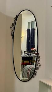 a mirror with a black frame on a wall at Gite Escale en Ville in Louviers