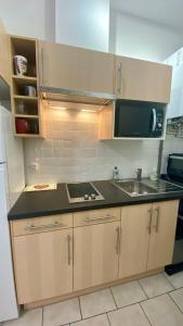 a kitchen with a sink and a microwave at Gite Escale en Ville in Louviers