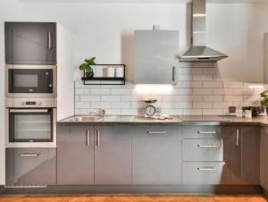 a kitchen with stainless steel cabinets and a sink at Allen Home in Bang Bua Thong Railway Station