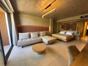 a bedroom with a couch and a bed and a table at Elegance Suites in Pyrgos
