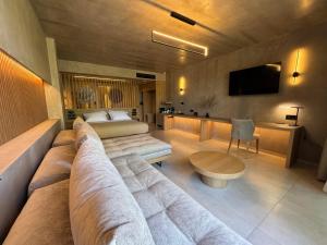 a living room with a couch and a bed at Elegance Suites in Pyrgos