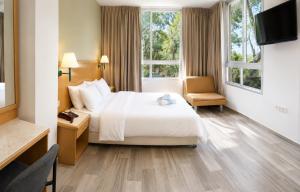 a hotel room with a bed and a chair at Marom Residence Romema in Haifa
