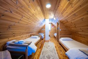 a room with four beds in a wooden cabin at Guest House SARA in Žabljak