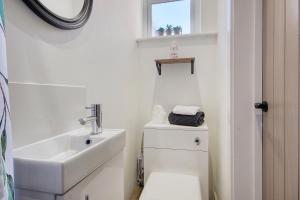 a white bathroom with a sink and a toilet at The Studio Castle Lane in Bournemouth