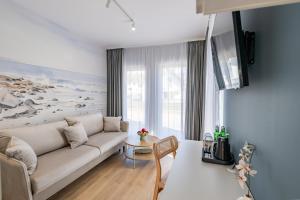 a living room with a couch and a table at Apartamenty i pokoje deluxe PÓŁNOCNA PRZYSTAŃ in Przewłoka +111 photos