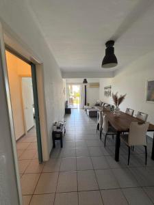 a dining room with a table and chairs at Kinetious Nisous Stylish Apt, Pool, near the Beach in Kineta