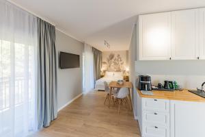 a kitchen with a desk and a bed in a room at Apartamenty i pokoje deluxe PÓŁNOCNA PRZYSTAŃ in Przewłoka