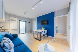 a living room with a blue couch and a table at Apartamenty i pokoje deluxe PÓŁNOCNA PRZYSTAŃ in Przewłoka