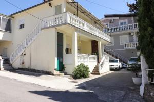a white house with a balcony on a street at Bonaca Room in Donja Lastva