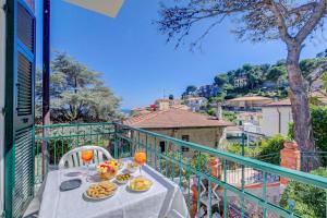 a table with plates of food on a balcony at Seaview Pool Retreat - Il Poggio in Marina di Andora