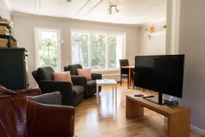 a living room with a flat screen tv on a table at Cozy Smalandcottage Alsterfors 23 - towels, bed linen and toiletries provided - in Alsterfors