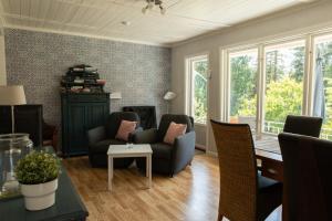 a living room with two chairs and a table at Cozy Smalandcottage Alsterfors 23 - towels, bed linen and toiletries provided - in Alsterfors