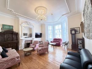 a living room filled with furniture and a chandelier at Vernon Guesthouse in Eastbourne