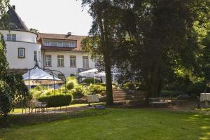 ダルムシュタットにあるHofgut Dippelshof Hotel- und Restaurant KGの椅子と芝生の家
