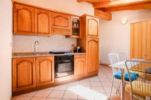 a kitchen with wooden cabinets and a sink and a stove at Residenza Garibaldi - Cirmolo in Molveno
