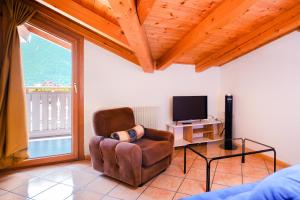 a living room with a chair and a television at Residenza Garibaldi - Cirmolo in Molveno