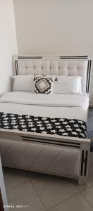 a bed with a black and white comforter and pillows at Studio BNB Meru town CBD in Meru