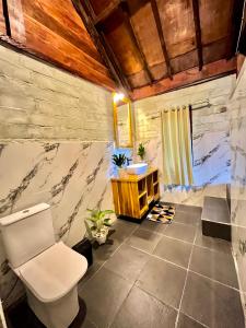 a bathroom with a toilet and a sink at Aulia Bungalows Tetebatu in Tetebatu +126 photos
