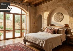 a bedroom with a large bed in a stone wall at Beit Madaba in Madaba
