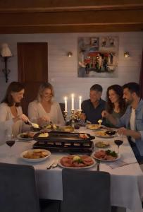 a group of people sitting around a table eating food at Chambres à l'écrin de bois in Guerlédan