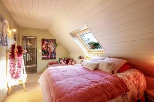 a bedroom with a large bed in a attic at Chambres à l'écrin de bois in Guerlédan