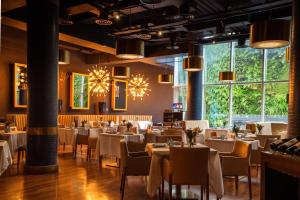 a restaurant with tables and chairs and large windows at Icon Hotel in Santiago