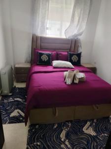 a bedroom with a purple bed with two towels on it at Dar hicham in Hajreien