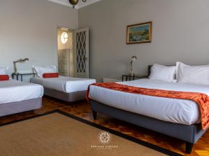 a hotel room with two beds and a rug at Espinho Vintage - Alojamento de Charme in Espinho
