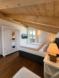 a bedroom with a large bed and a wooden ceiling at Alpenwohnung Neuner in Wallgau