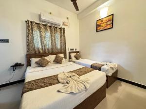 a bedroom with two beds and a window at La Paradise Residency - TIE in Pondicherry +61 photos